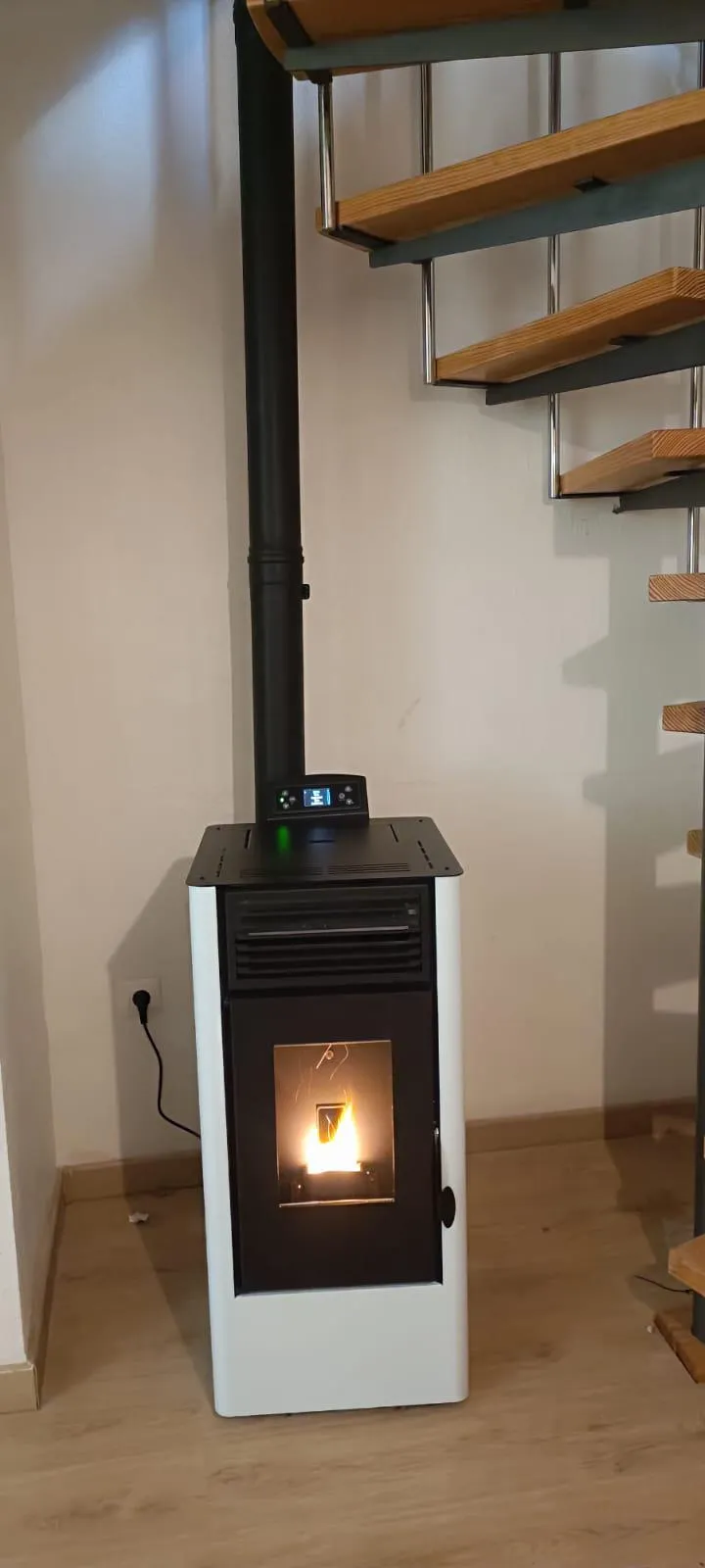 Estufa de leña encendida instalada en el salón de una vivienda